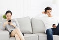 Couple sitting on couch and watching their phonesÃÂ  Royalty Free Stock Photo